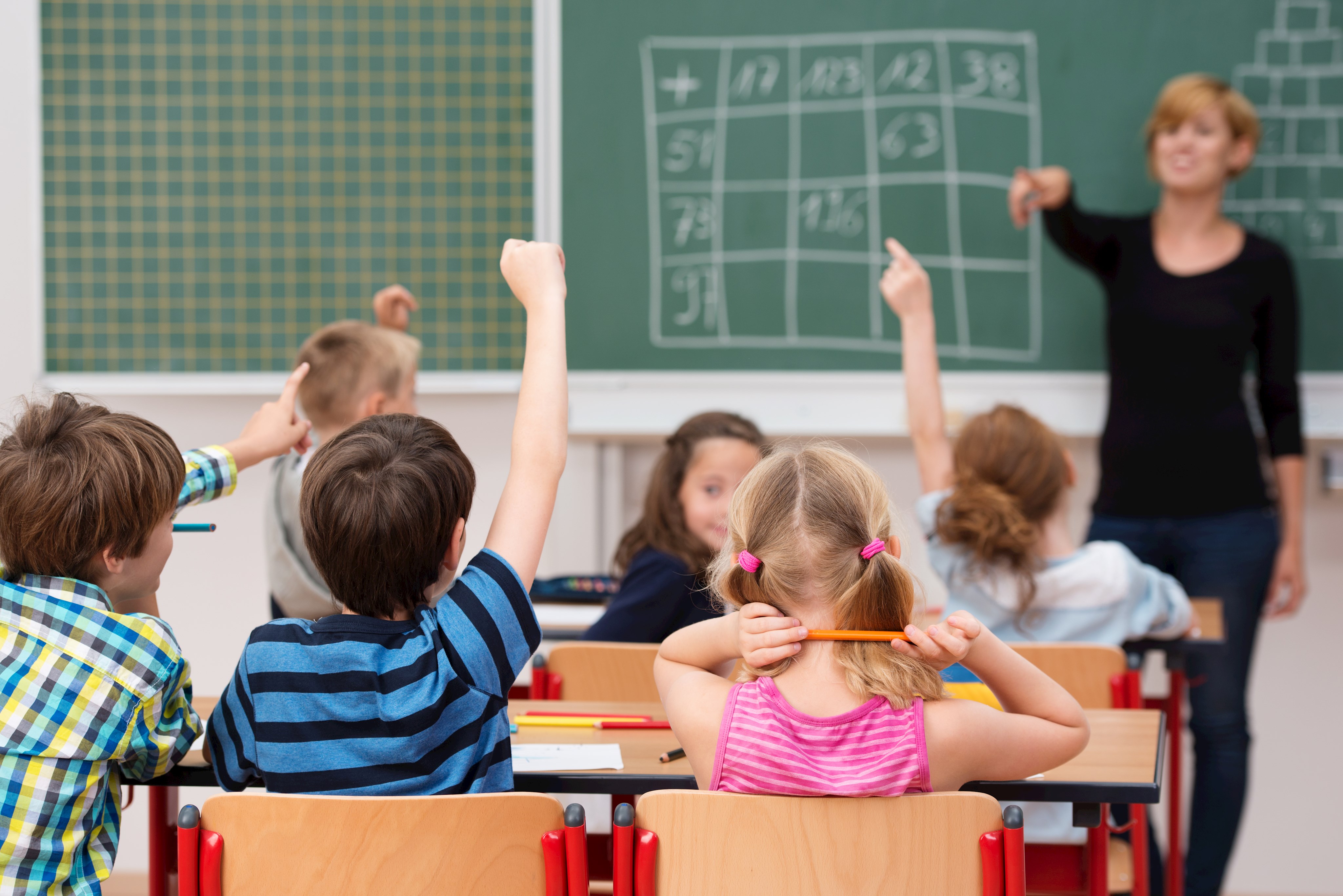 Lehrerin ruft Schüler auf, die sich im Klassenzimmer melden