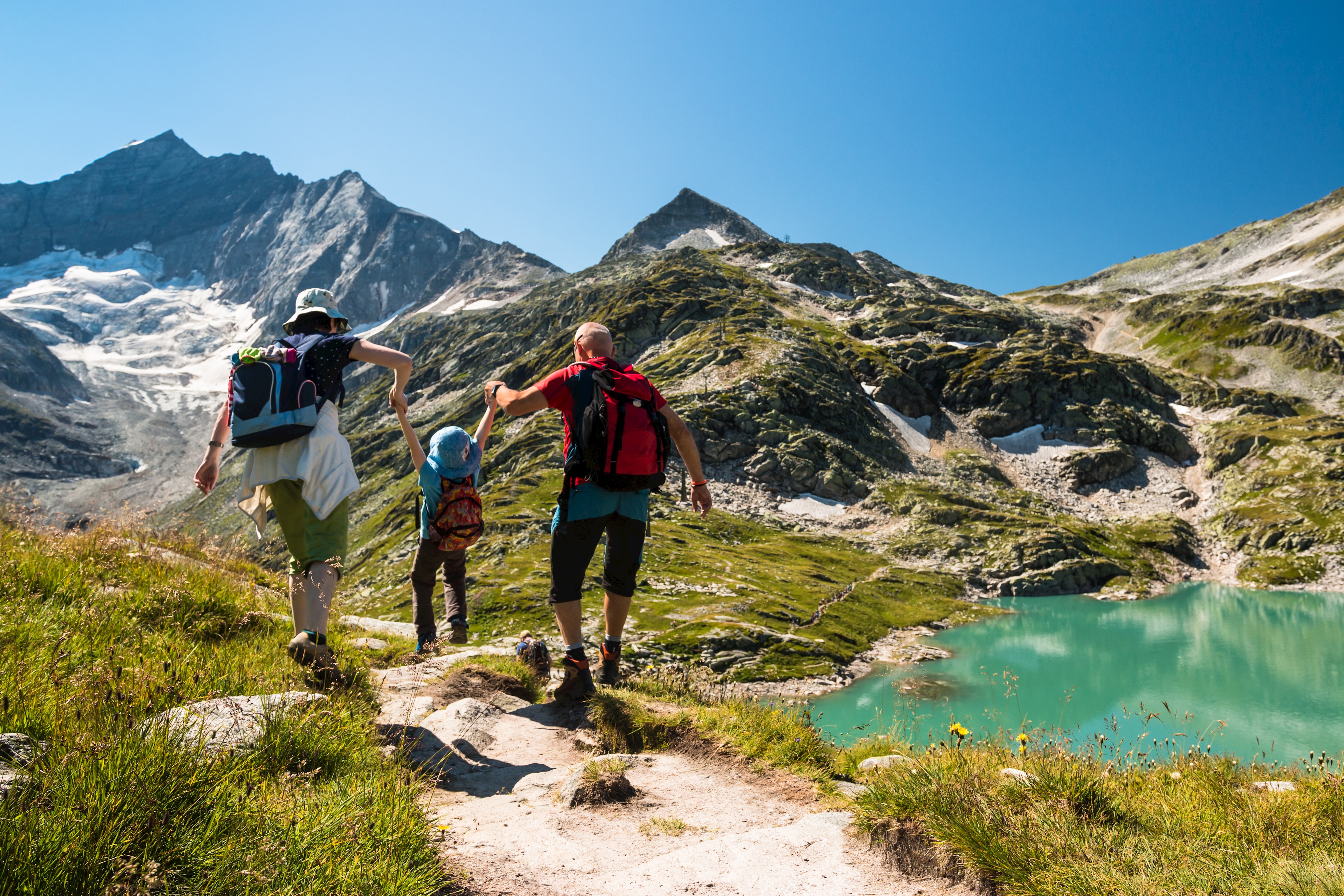 Gipfeltour Familie an blauem Bergsee bei schönem Wetter