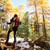 Ein Wanderer mit Gepäck und Stöcken im sonnigen, verschneiten Wald Ein Wanderer mit Gepäck und Stöcken im sonnigen, verschneiten Wald